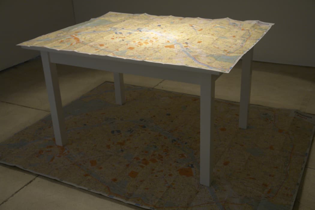 P THE STREETS OF PARIS

Jorge Macchi, The City of Light, 2007
Lamp, table, map, digital print on paper
Inhotim Collection, Brumadinho, Brazil

Maps are among Jorge Macchi’s favorite materials: he has charted urban itineraries that correspond to the branching cracks in a pane of glass; surgically cut away all elements of a city but its streets, rivers, or cemeteries; and used countries as collage elements, overlapping haphazardly as if fallen across a page.

Benjamin was fascinated by the tangled labyrinth of Paris streets, the subject of Convolute P. The unexpected constellations of people, places, historical events, and phrases that give their names to the old city’s streets represent the chaotic plenitude of its history, enticing the adventurous flâneur.