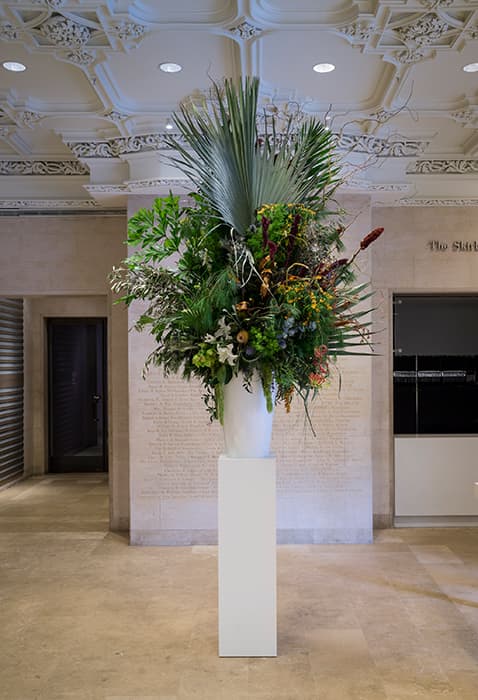 Installation view of Using Walls, Floors and Ceilings: Willem de Rooij, Bouquet XI, 2014. White fiberglass vase, plinth, flower arrangement of allergenic flowers originating from the Middle East, first version created by Bella Meyer, New York. Courtesy of Petzel Gallery, New York, and Regen Projects, Los Angeles. Photo by: David Heald