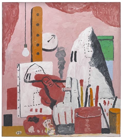 Painting by Philip Guston depicting a hooded figure seated at a desk, drawing its own image, surrounded by everyday objects like a light bulb, clock, brushes, and containers, set against a pink background.