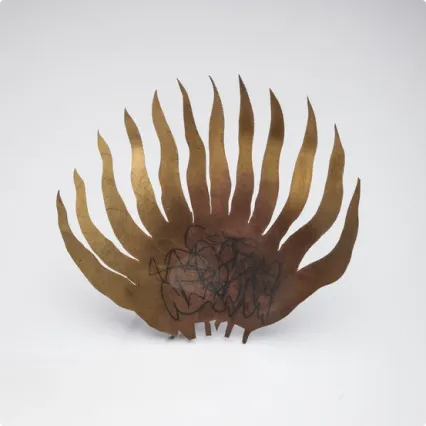 Bronze sculpture resembling a stylized fan or sunburst, with twelve elongated, curved spikes radiating upward and outward from a central base. The center features abstract engraved lines.